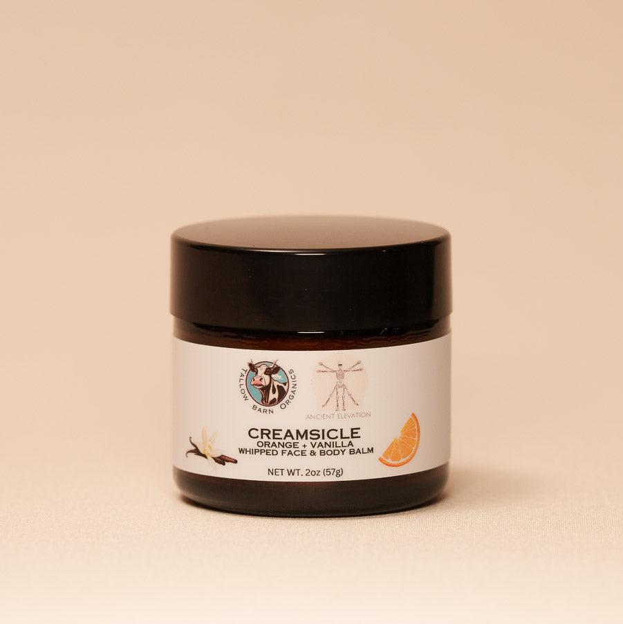 A jar of creamy whipped tallow balm with a simple label, showcasing its rich texture and natural ingredients, set against a soft, light backdrop.