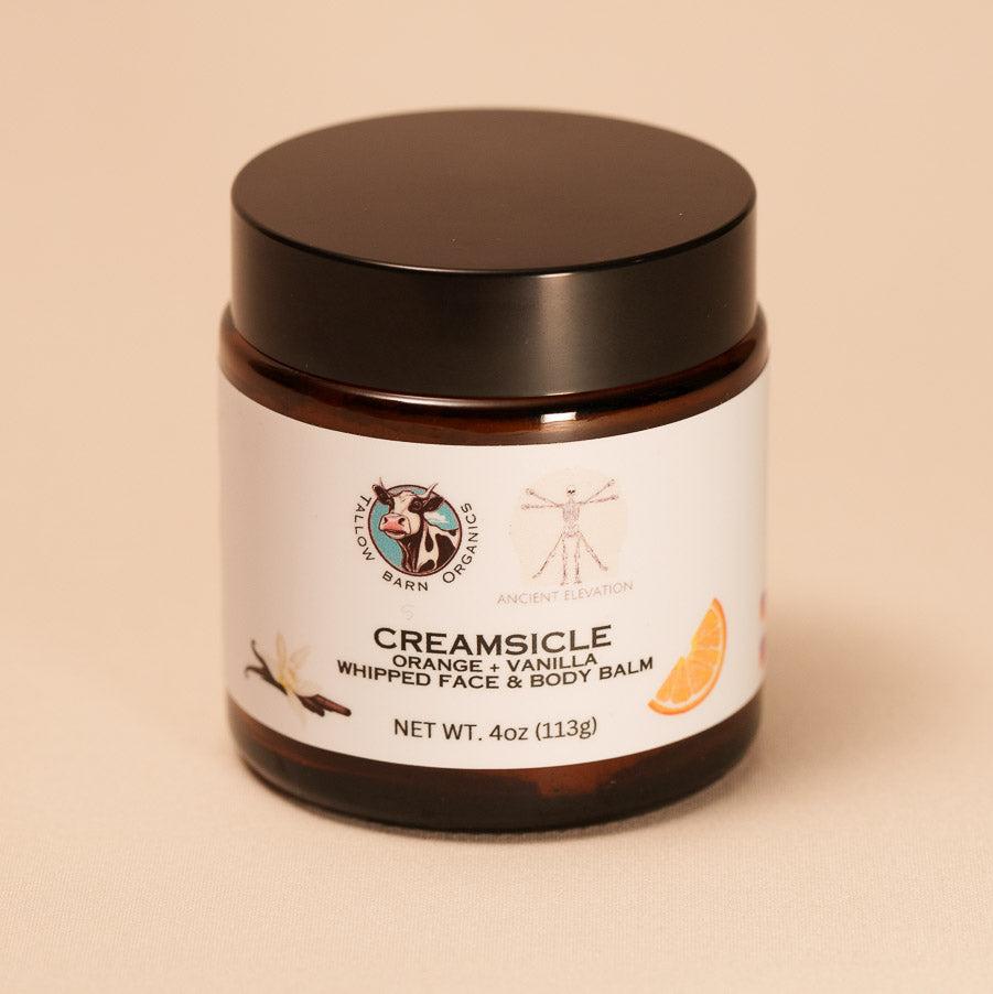 A jar of creamy whipped tallow balm with a simple label, showcasing its rich texture and natural ingredients, set against a soft, light backdrop.